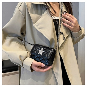 Close-up of black quilted mini bag featuring a sparkling star emblem and chain strap