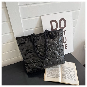 Détail du sac fourre-tout noir matelassé avec motif d'étoiles et poignées en corde