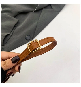Détail de la sangle en cuir PU marron avec boucle en métal doré et surpiqûres de qualité