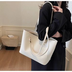 Chic cream tote bag with fine leather texture and metallic hardware shown on model
