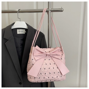 Detail of pink seersucker tote bag featuring bubble texture and large bow decoration