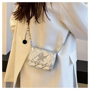 Detail of silver quilted crossbody bag featuring a sparkling star and metal chain strap