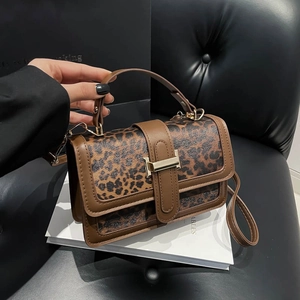 Détail de l'imprimé léopard et du cuir brun avec boucle métallique H iconique