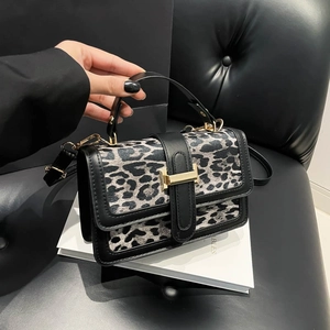 Détail du sac à main léopard avec fermoir doré en H et finitions en cuir noir