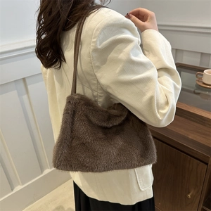 Deep brown faux fur shoulder bag with slender leather strap worn with white corduroy jacket