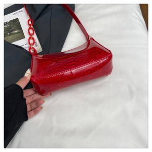 Close-up detail of red snake skin pattern leather and thick resin chain on shoulder bag