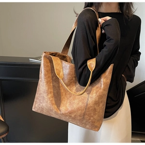 Macro shot of the vintage brown tote bag showing its matte faux leather texture and detail