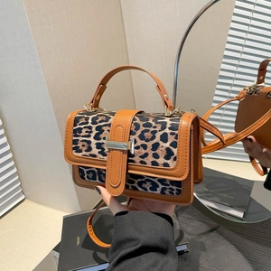 Détail de la texture léopard en fausse peau et des finitions en cuir marron du sac à main