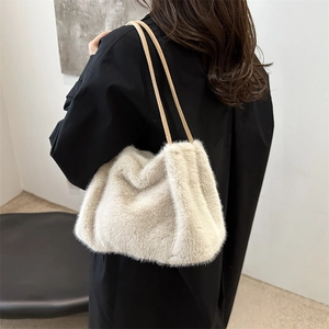 Cream white faux fur tote bag with brown straps styled on a black outfit for winter