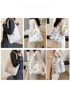 White suede tote bag with grey butterfly print showing different carrying styles on a model