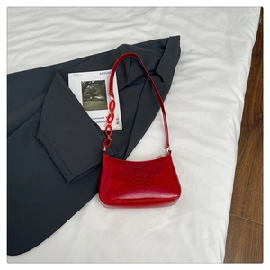 Macro shot of red snake pattern baguette bag with stylish acrylic chain strap