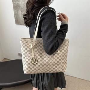 Minimalist beige tote bag with M-pattern monogram and gold charm for daily commute
