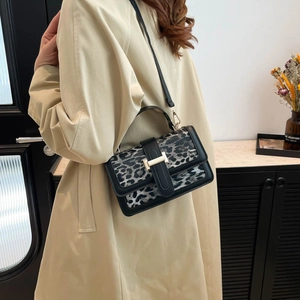 Détail du sac bandoulière à motif léopard avec bordures en cuir et boucle dorée