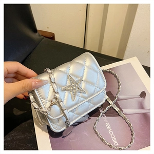 Macro detail of silver quilted chain bag with rhinestone star and metallic finish