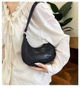 Détail du sac hobo noir à motif crocodile avec des anneaux en métal doré chic