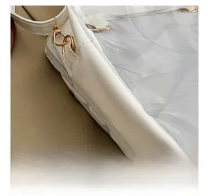 Detail view showing golden metal hardware, zipper, and white grid lining on the bag