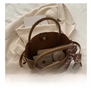 Sac seau en cuir marron montrant l'espace intérieur pour portefeuille et cosmétiques