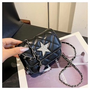 Close-up of black quilted crossbody bag featuring a sparkling silver star and chain strap
