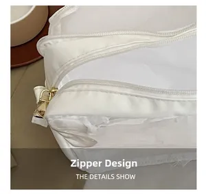 Detail view of smooth white mesh material with high-quality golden metal zipper slider
