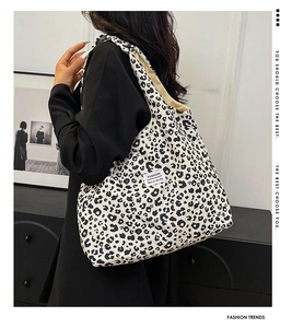 Detail view of large leopard print tote bag with fashion label on canvas material