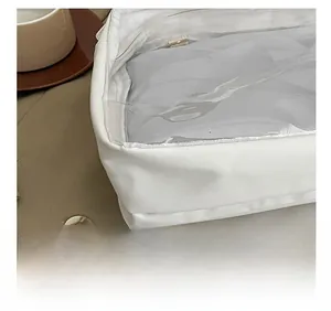 Detail shot of precise stitching on a white leather shoulder bag with clear PVC window