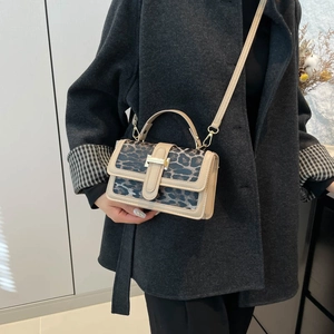 Détail d'un sac bandoulière à motif léopard avec boucle dorée et sangle réglable
