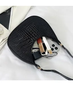 Détail du sac sous l'aisselle en cuir de crocodile noir montrant l'espace intérieur