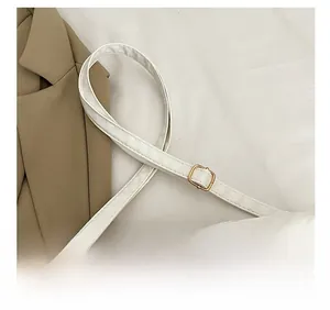 Detail shot of the adjustable shoulder strap with premium gold metal buckle on white bag