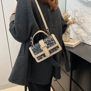 Petit sac carré à imprimé léopard porté en bandoulière par un mannequin avec style