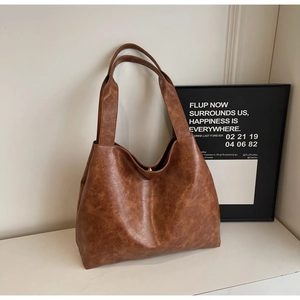 Detail of vintage brown tote bag showing supple PU leather texture and magnetic closure