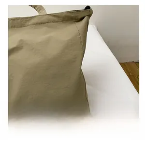 Dettaglio ravvicinato della borsa tote in tela kaki con cuciture fini e tessuto in nylon