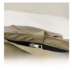 Dettaglio della cerniera scorrevole e del tessuto in nylon sulla borsa tote color kaki