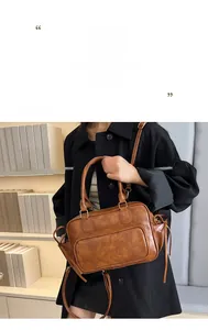 Retro brown leather Boston bag worn crossbody by model in casual style