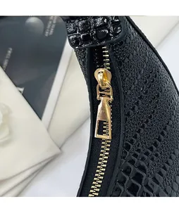 Détail du cuir verni noir à motif crocodile avec curseur de fermeture doré luxueux