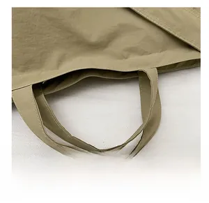 Dettaglio delle cuciture rinforzate sul manico della borsa tote in tela kaki per la durata
