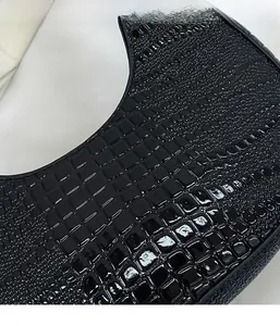 Détail de la texture en cuir gaufré crocodile noir brillant avec reflets de lumière