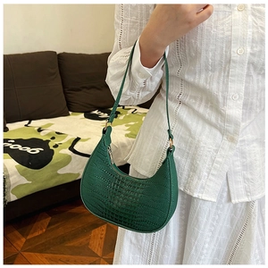 Gros plan sur le sac baguette vert émeraude avec texture en relief crocodile détaillée