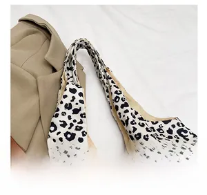 Detail showing the comfortable wide shoulder strap of the leopard print canvas bag
