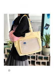 Dettaglio di una borsa tote in tela gialla con tasca a rete ed elementi di cucitura a contrasto