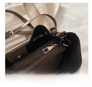 Macro detail of the smooth silver zipper and interior compartment of dark brown PU bag
