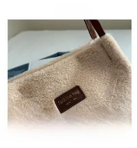 Macro view of fluffy beige faux fur texture with brown leather fashion logo patch