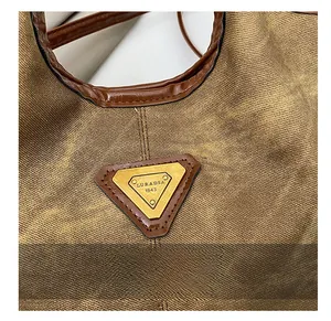 Detailed close-up of a vintage metallic triangle logo plaque on textured tote bag