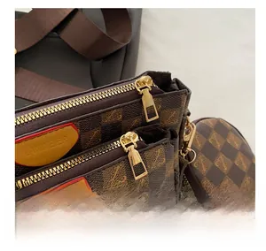 Close-up of dual-zipper structure and golden hardware on brown checkered crossbody bag