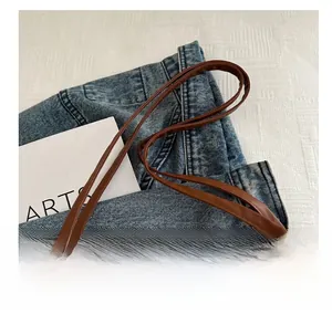 Close-up of brown faux leather straps attached to a beige fluffy faux fur tote bag