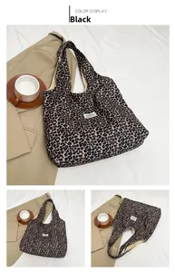 Detail view of large leopard print tote bag with black fabric label and soft texture