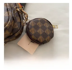 Close-up of a small round retro brown purse charm with luxury pattern and gold zipper