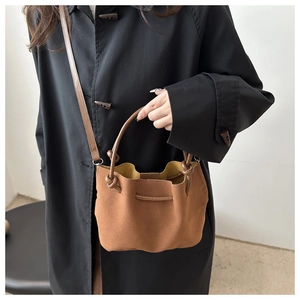 Caramel brown suede bucket bag with contrast yellow lining and a round handle