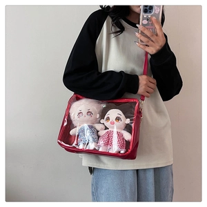 Detail of red transparent ita bag window with plush dolls and adjustable shoulder strap