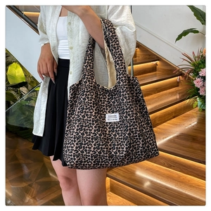 Close-up of leopard print shoulder bag featuring a white fashion label and nylon texture