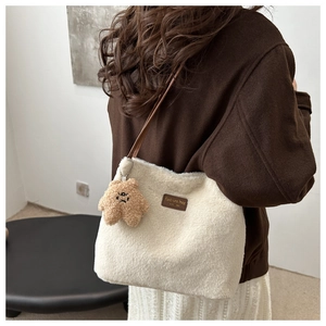 Detail showing plush winter tote with brown leather straps and star charm